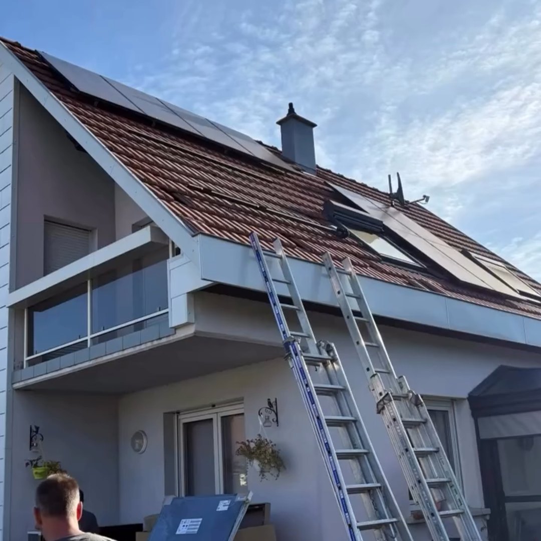Technicien Ertlé & Fils posant des panneaux solaires thermiques DE DIETRICH sur la toiture